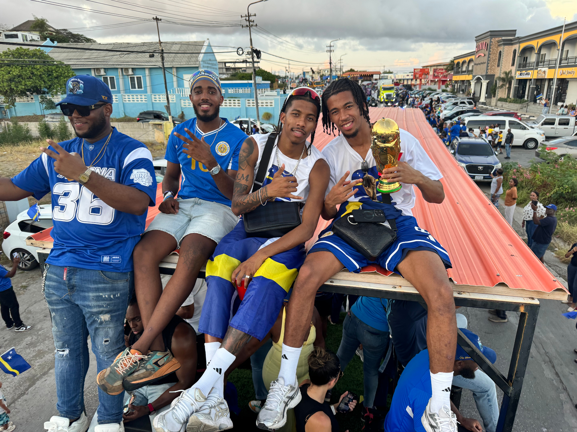 Players holding the trophy on the parade truck.